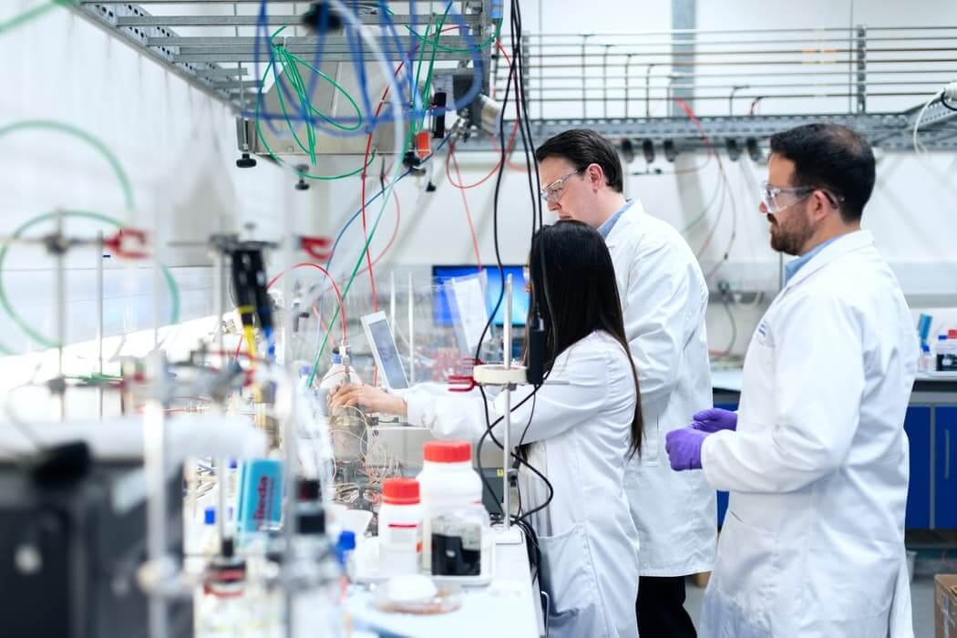 Fotografía de tres químicos en un laboratorio: un ejemplo de entorno en el que es necesario limpiar el aire de covid y otras partículas