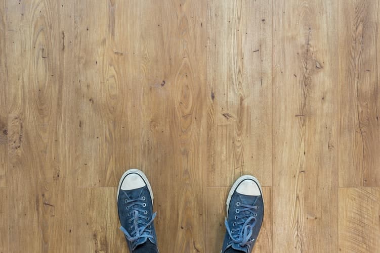 Imagen de unos pies sobre un suelo de madera con calefacción radiante